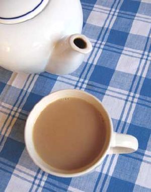 Photo of a cup of tea on a table with a plaid table cloth