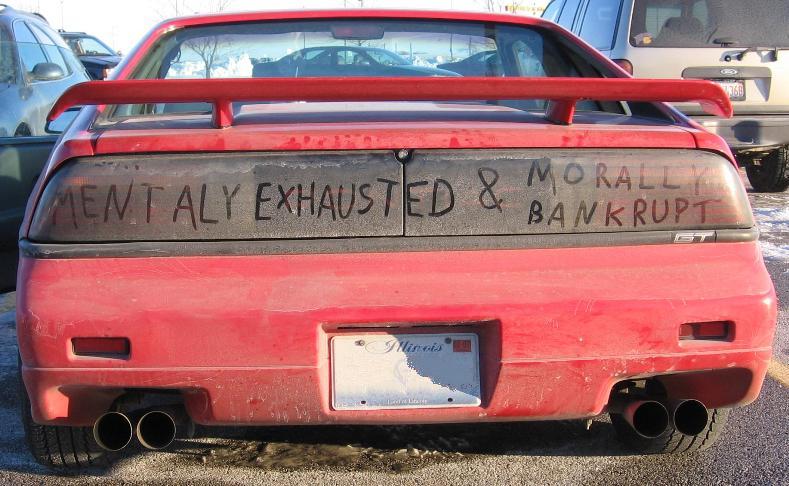 Mentally Exhausted and Morally Bankrupt scrawled on the rear of a wrecked car